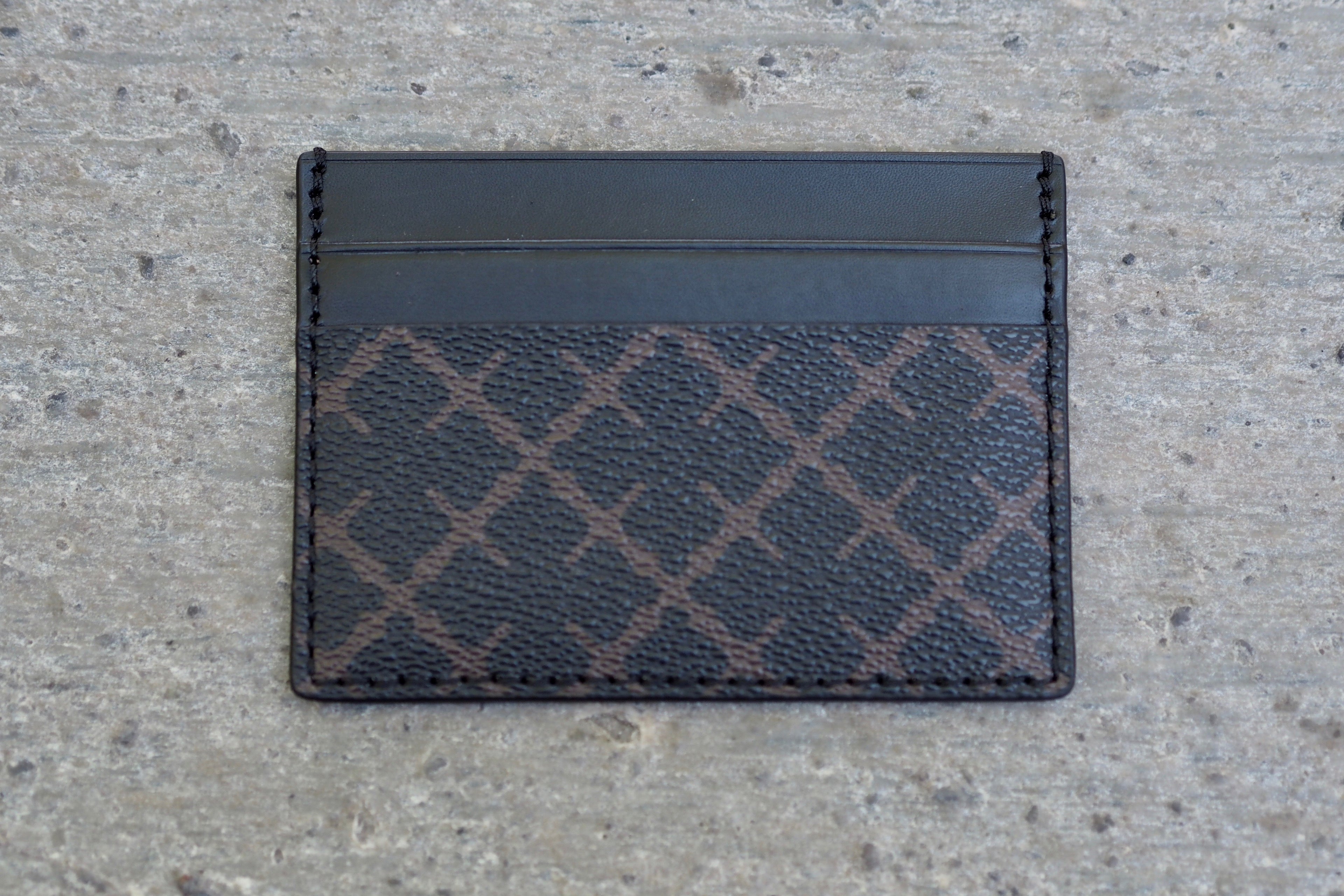 By Malene Birger Elia Card kortholder i brun, laget av 100% polyvinylklorid, med Signature Flower-print og plass til flere kort.