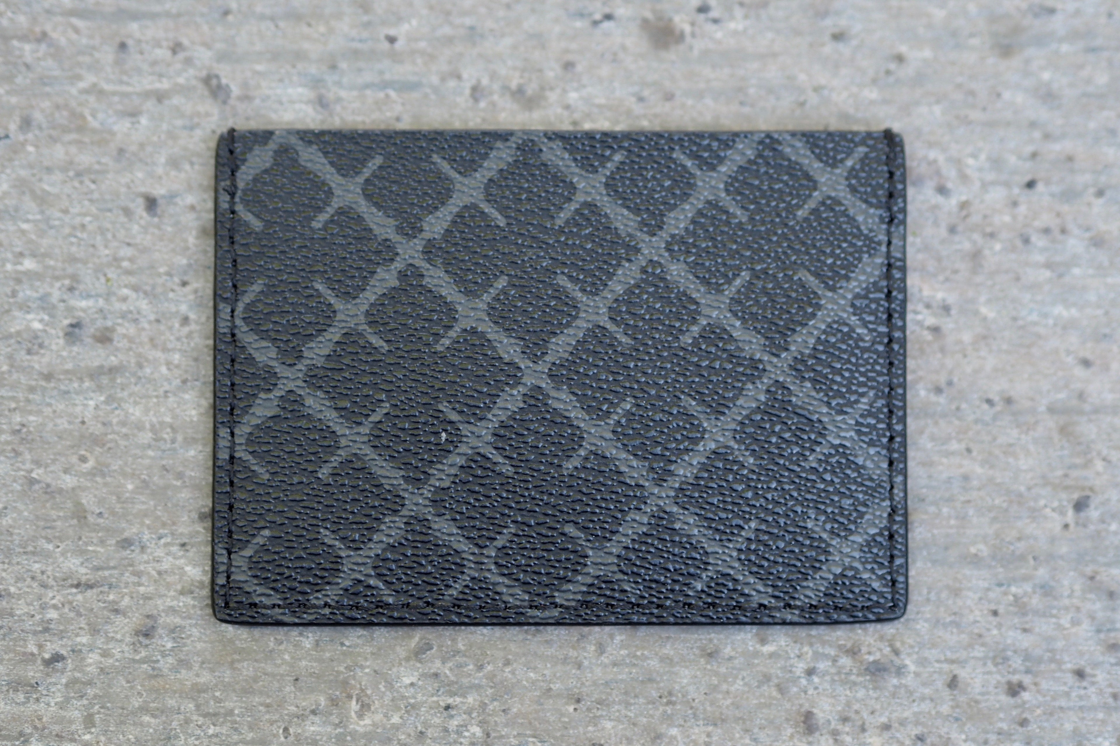 By Malene Birger Elia Card kortholder i koksgrå, laget av 100% polyvinylklorid, med Signature Flower-print og plass til flere kort.