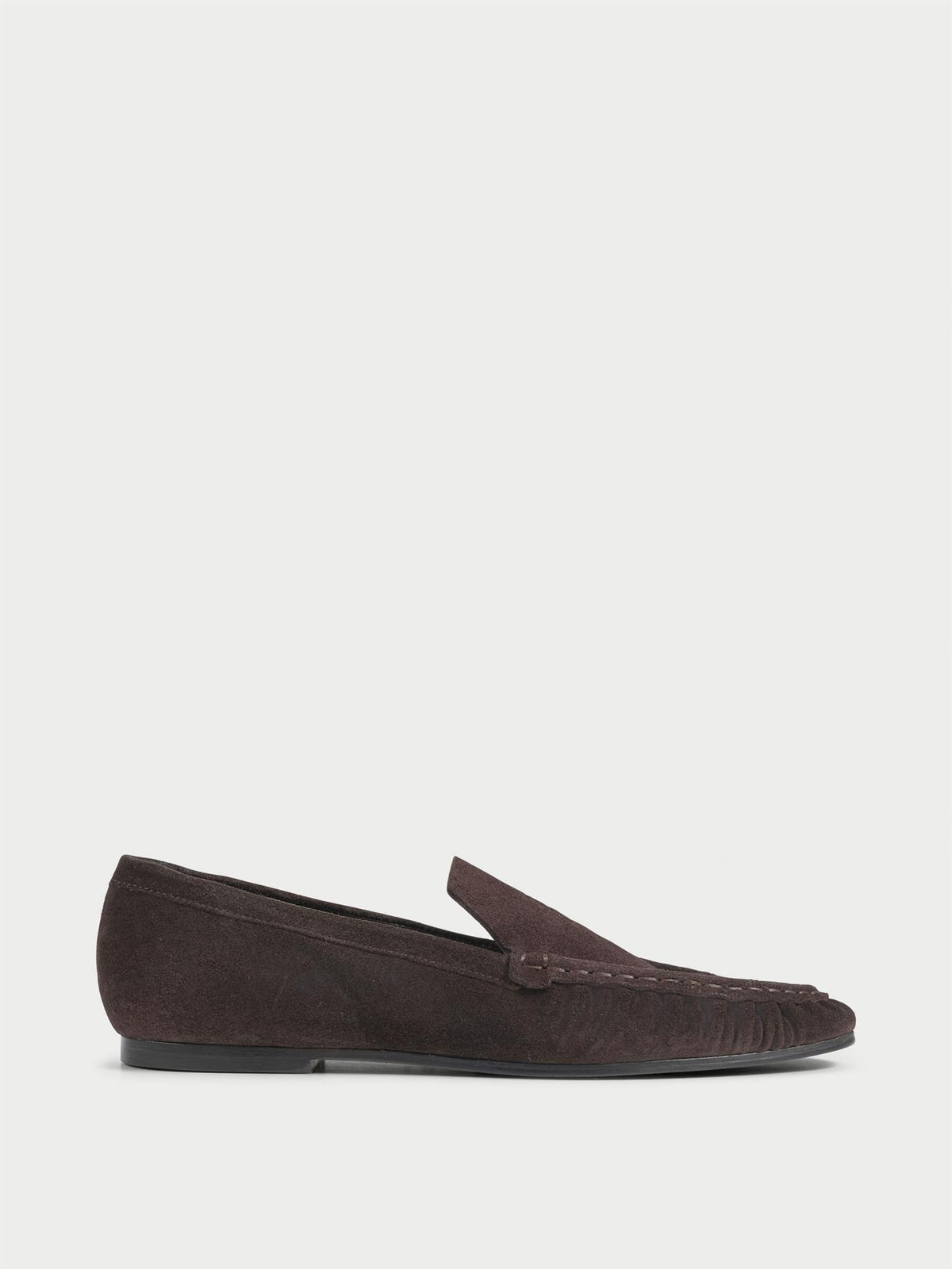 ELISA loafers fra By Malene Birger i fargen mørkebrun, laget i myk semsket skinn. Smal passform, rund tå og preget monogram over vristen.