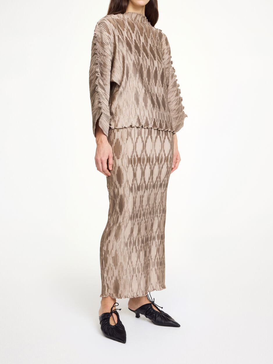 By Malene Birger Elisas skjørt i beige, laget av 100% resirkulert polyester med plissé-struktur og strikk i livet.