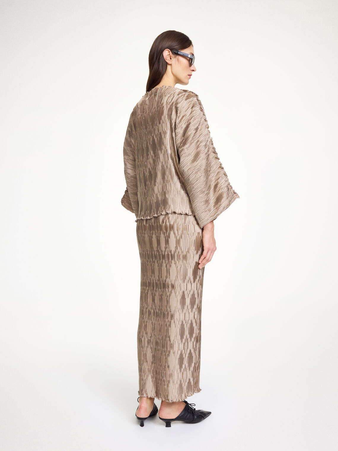 By Malene Birger Elisas skjørt i beige, laget av 100% resirkulert polyester med plissé-struktur og strikk i livet.