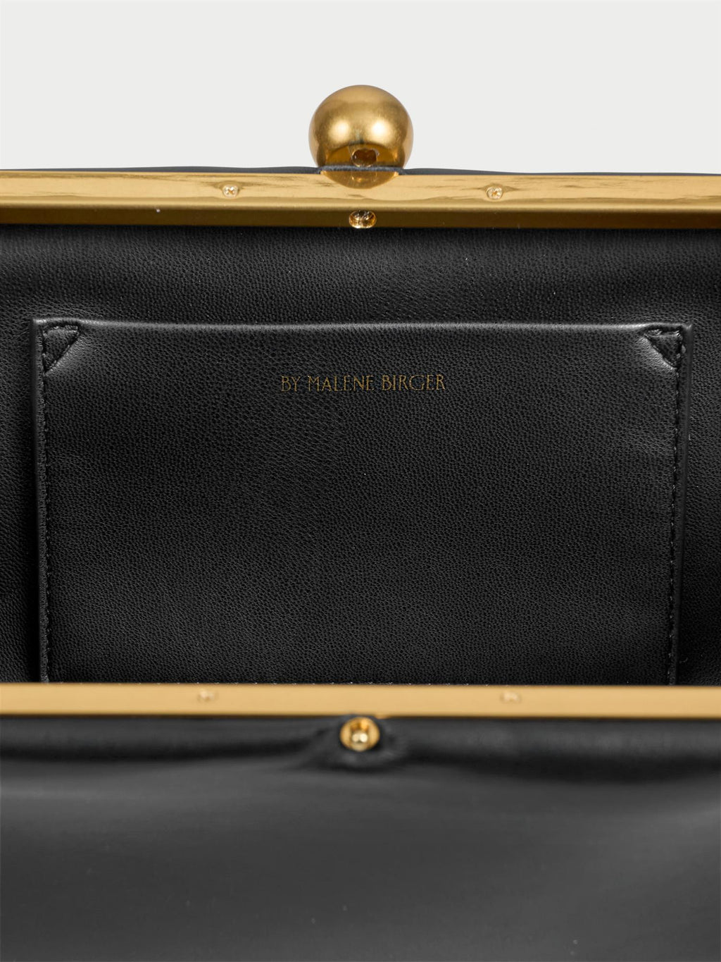 ELLON NAPPA veske fra By Malene Birger i fargen sort, laget i 100% kuskinn. Metallstropp, avtagbar skulderreim, innvendig lomme og "Kiss-Lock"-lukking.
