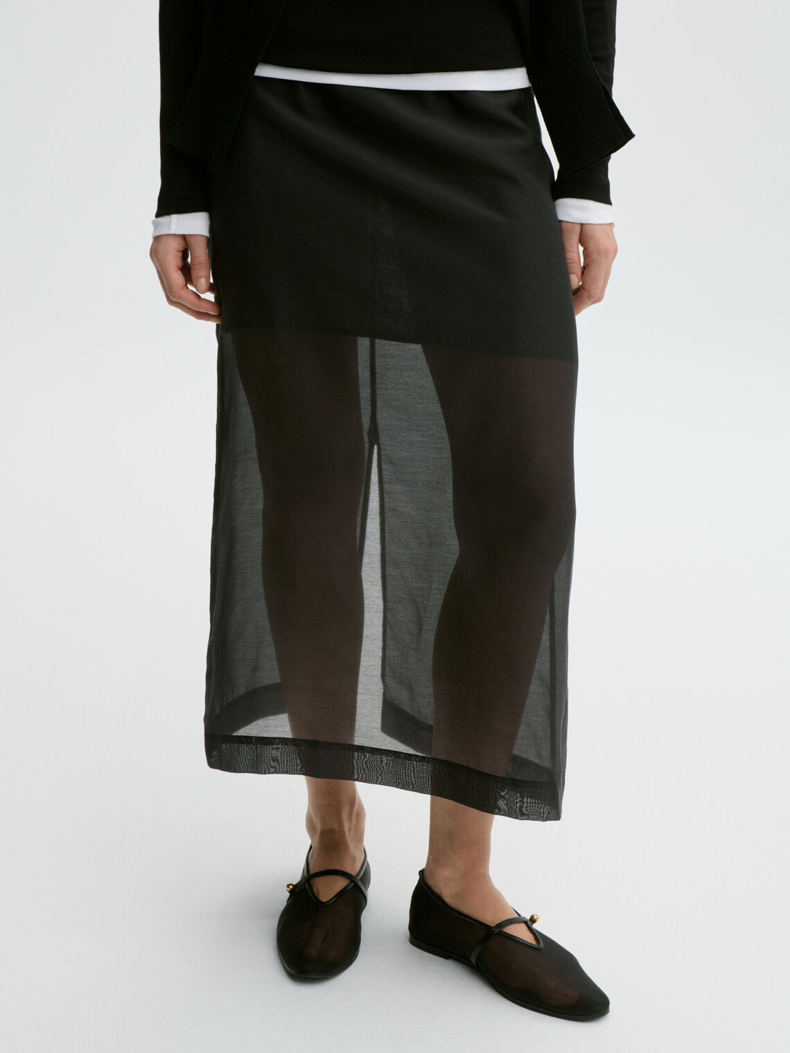 By Malene Birger Esta sort silkeskjørt, detalj av gjennomsiktig materiale og A-linjet snitt.