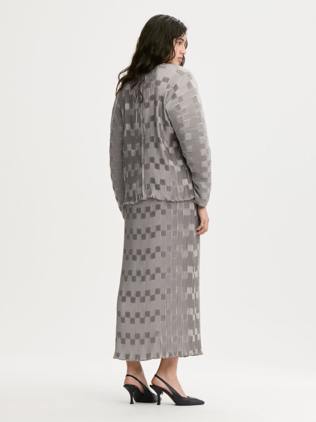 FRANCIS kjole fra By Malene Birger i fargen sølv, laget i 100% resirkulert polyester. Løs silhuett med v-hals og "dolman"-ermer.