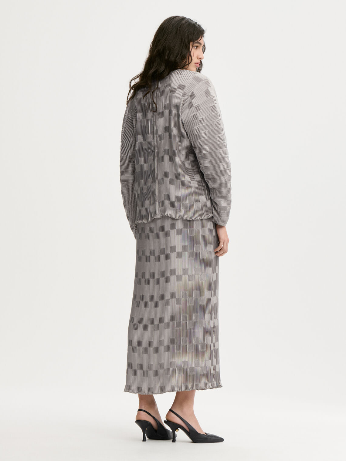 FRANCIS kjole fra By Malene Birger i fargen sølv, laget i 100% resirkulert polyester. Løs silhuett med v-hals og "dolman"-ermer.