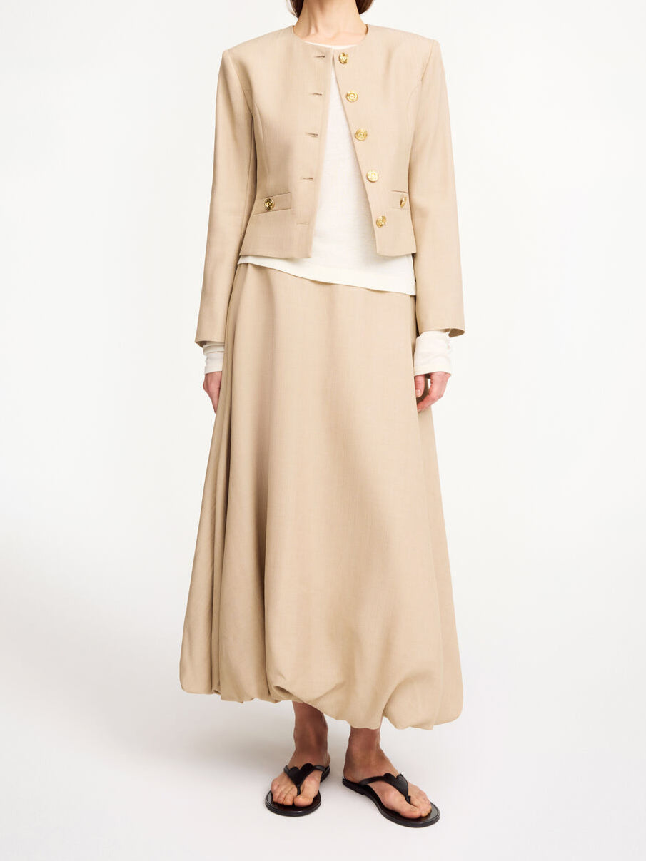 By Malene Birger Frida blazer i beige, med en feminin og nett passform, gullknapper og cropped lengde.