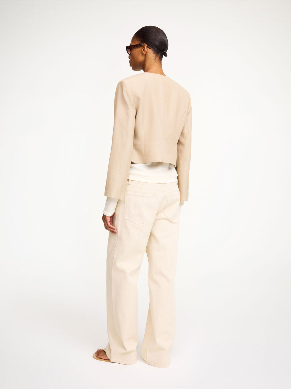 By Malene Birger Frida blazer i beige, med en feminin og nett passform, gullknapper og cropped lengde.