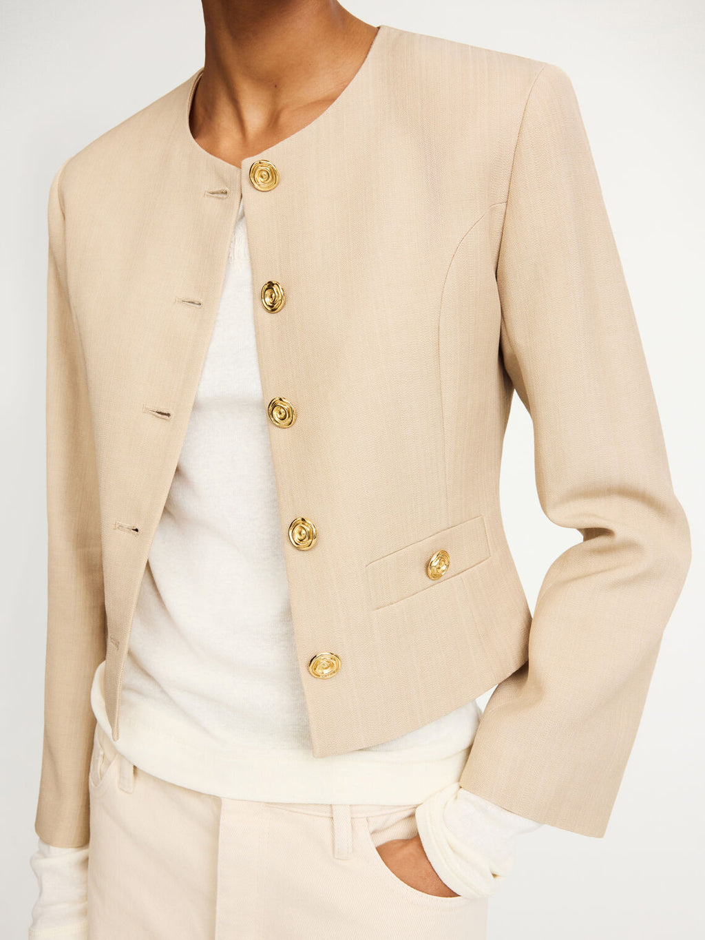 By Malene Birger Frida blazer i beige, med en feminin og nett passform, gullknapper og cropped lengde.