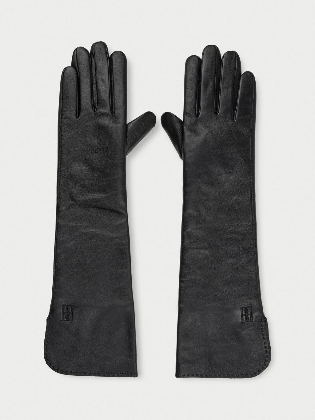 GEMILO hansker fra By Malene Birger i fargen sort, laget i 100% saueskinn. Albuehøye med brodert monogram.