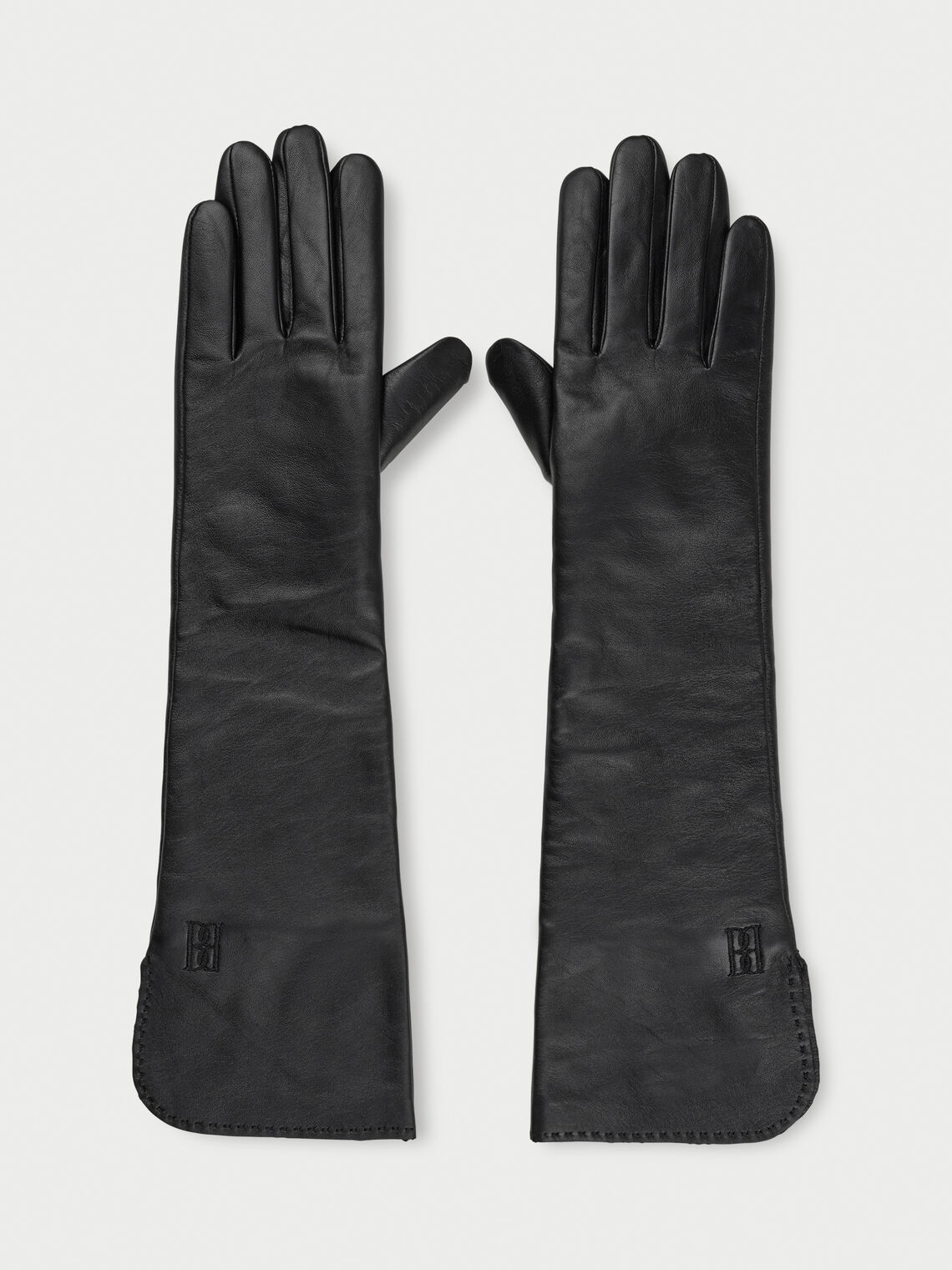GEMILO hansker fra By Malene Birger i fargen sort, laget i 100% saueskinn. Albuehøye med brodert monogram.