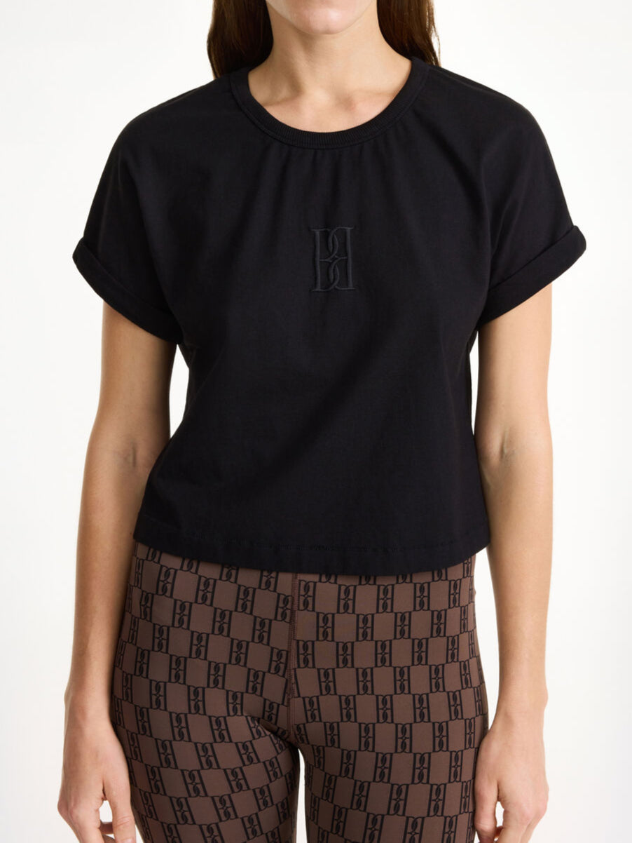 By Malene Birger Hedalia kort t-skjorte i svart, laget av 100% organisk bomull, med en cropped lengde og brodert monogram på brystet.