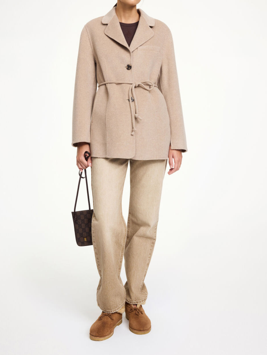 By Malene Birger Hellen jakke i beige, laget av 100% ull med en rett passform, avtagbart belte og buet krage.