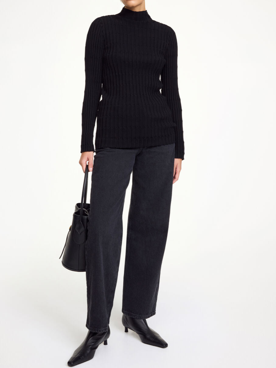 By Malene Birger Inger genser i sort, med nett høy hals og ribbestrikk, laget av merinoull og elastan.