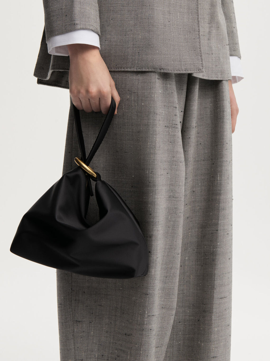 ISADORA SATIN clutch fra By Malene Birger i fargen sort, laget i polyester med spandex. Håndtak, gullfarget ringdetalj og lukkes med glidelås.