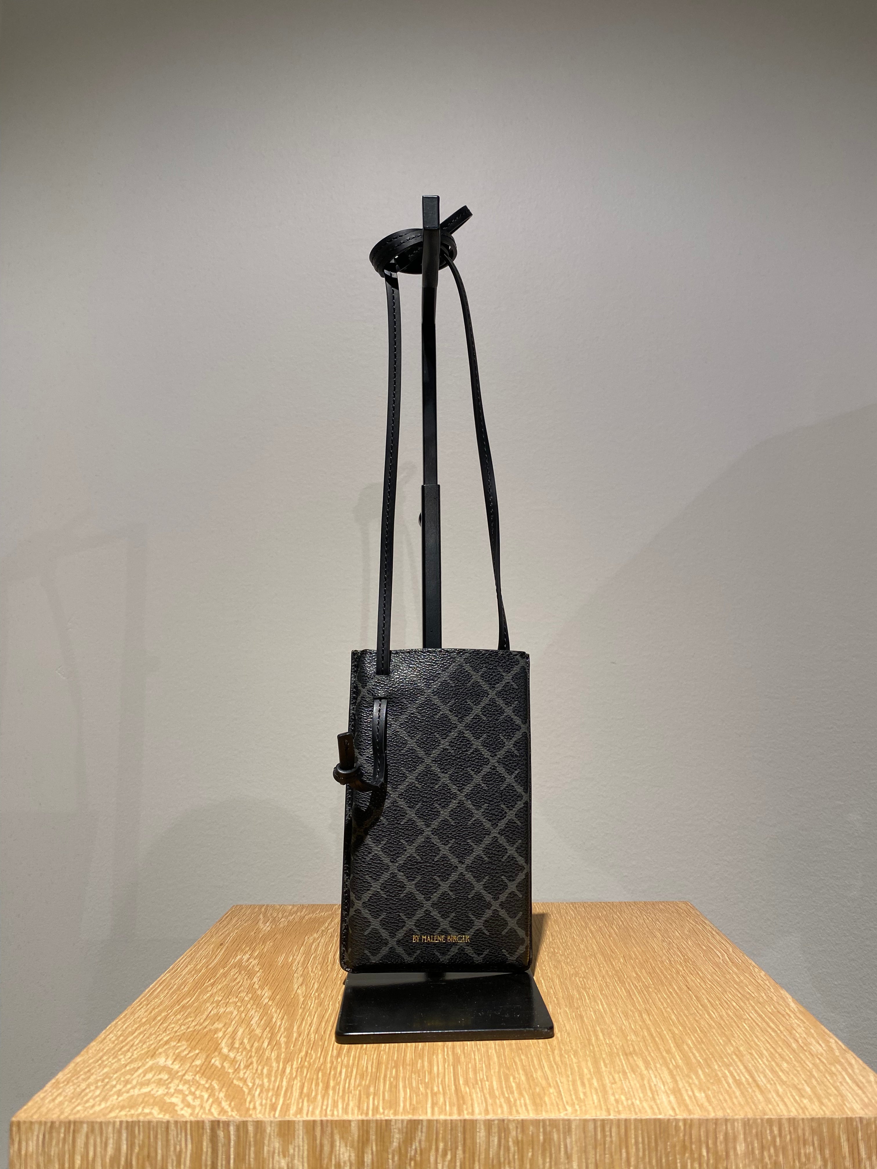 By Malene Birger Ivy mobilveske i  mørkegrå polyvinyl chloride, med Signature Flower-mønster.