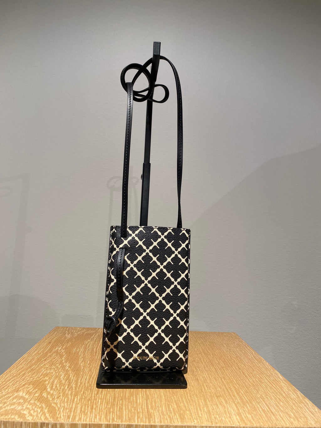 By Malene Birger Ivy mobilveske i sort polyvinyl chloride, med Signature Flower-mønster.