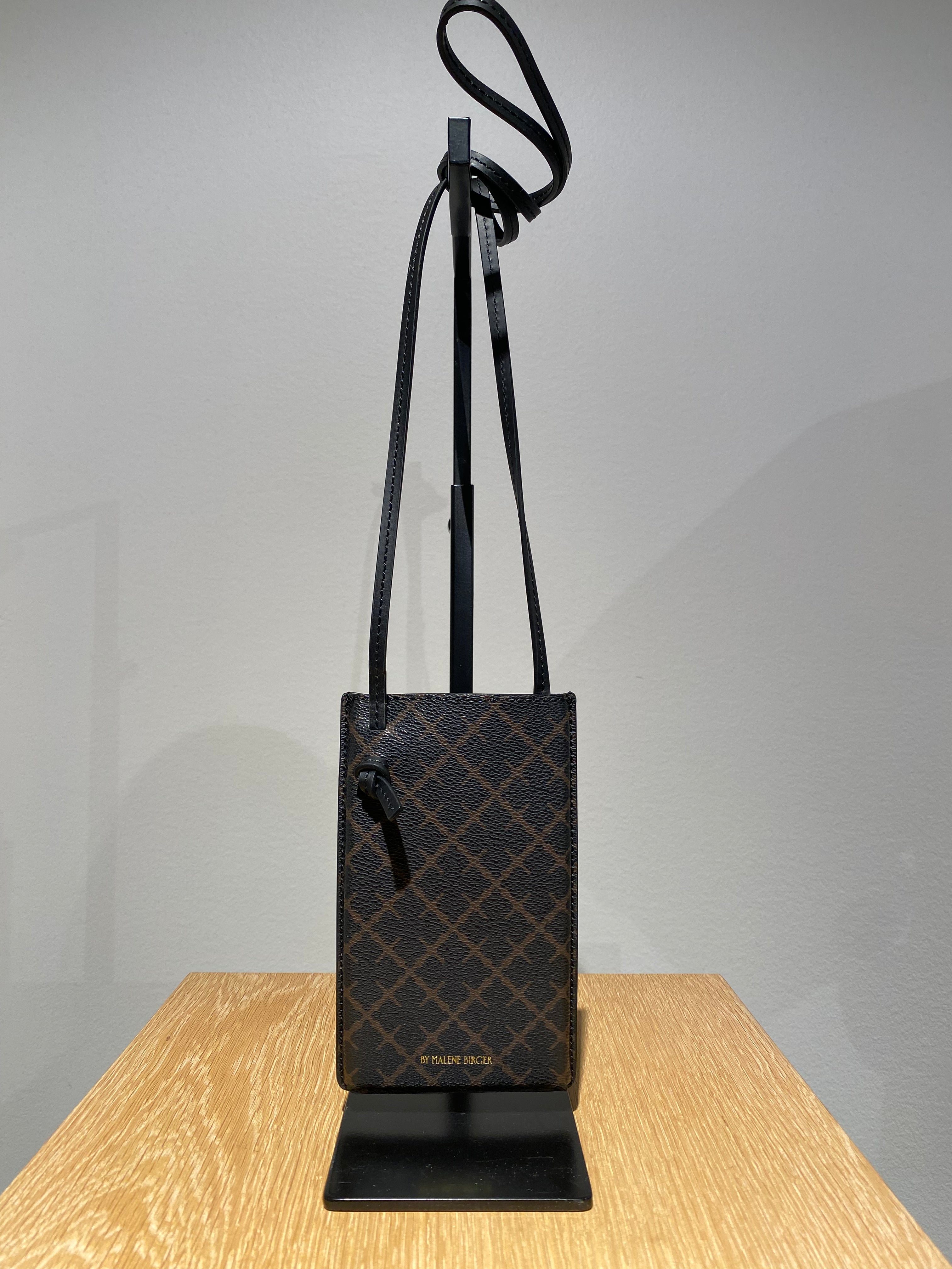 By Malene Birger Ivy Phone mobilveske i mørkebrun, laget av 100% polyvinylklorid med Signature Flower-print.