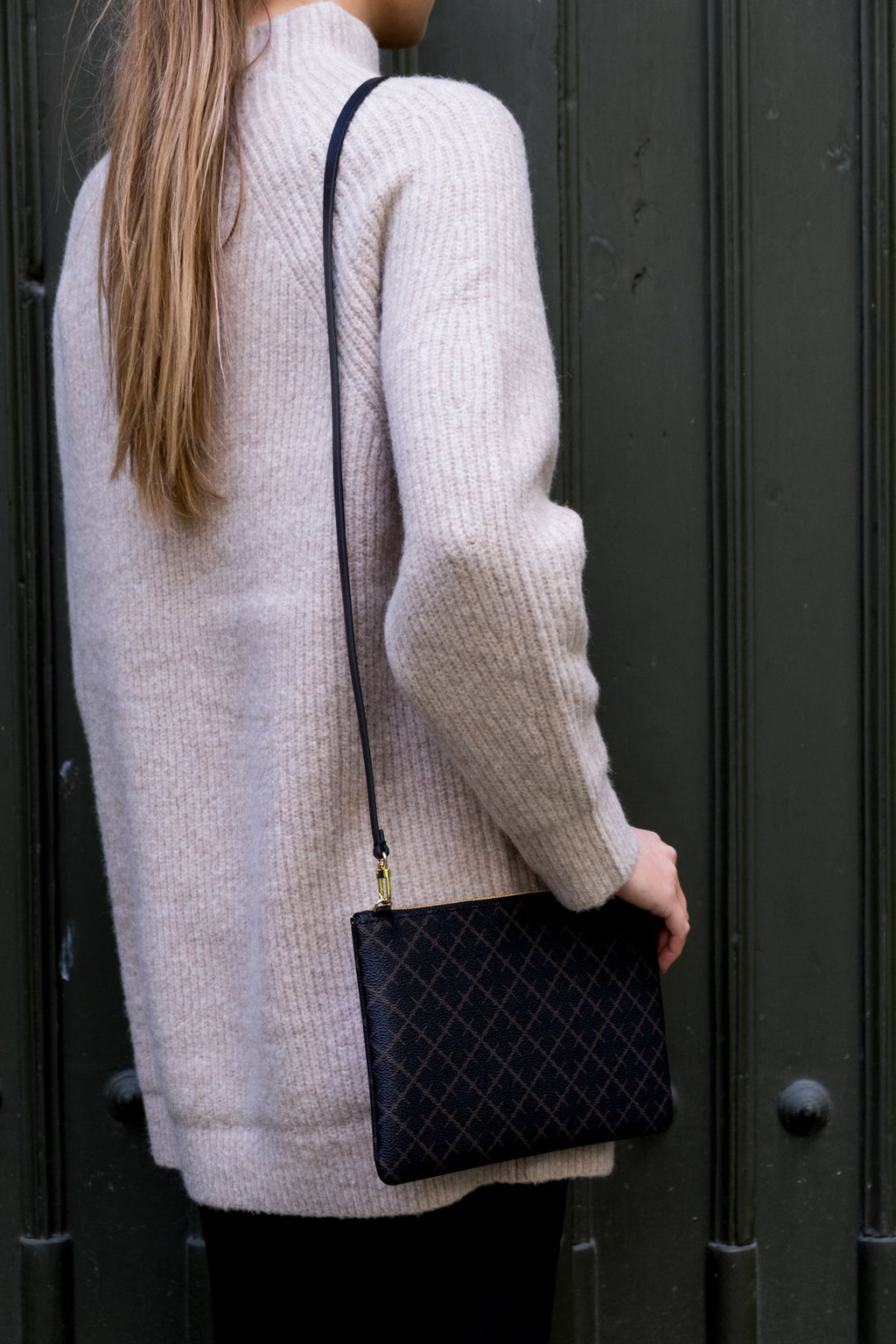 By Malene Birger Ivy veske i mørkebrun, firkantet form, med Signature Flower-mønster og avtagbar stropp.