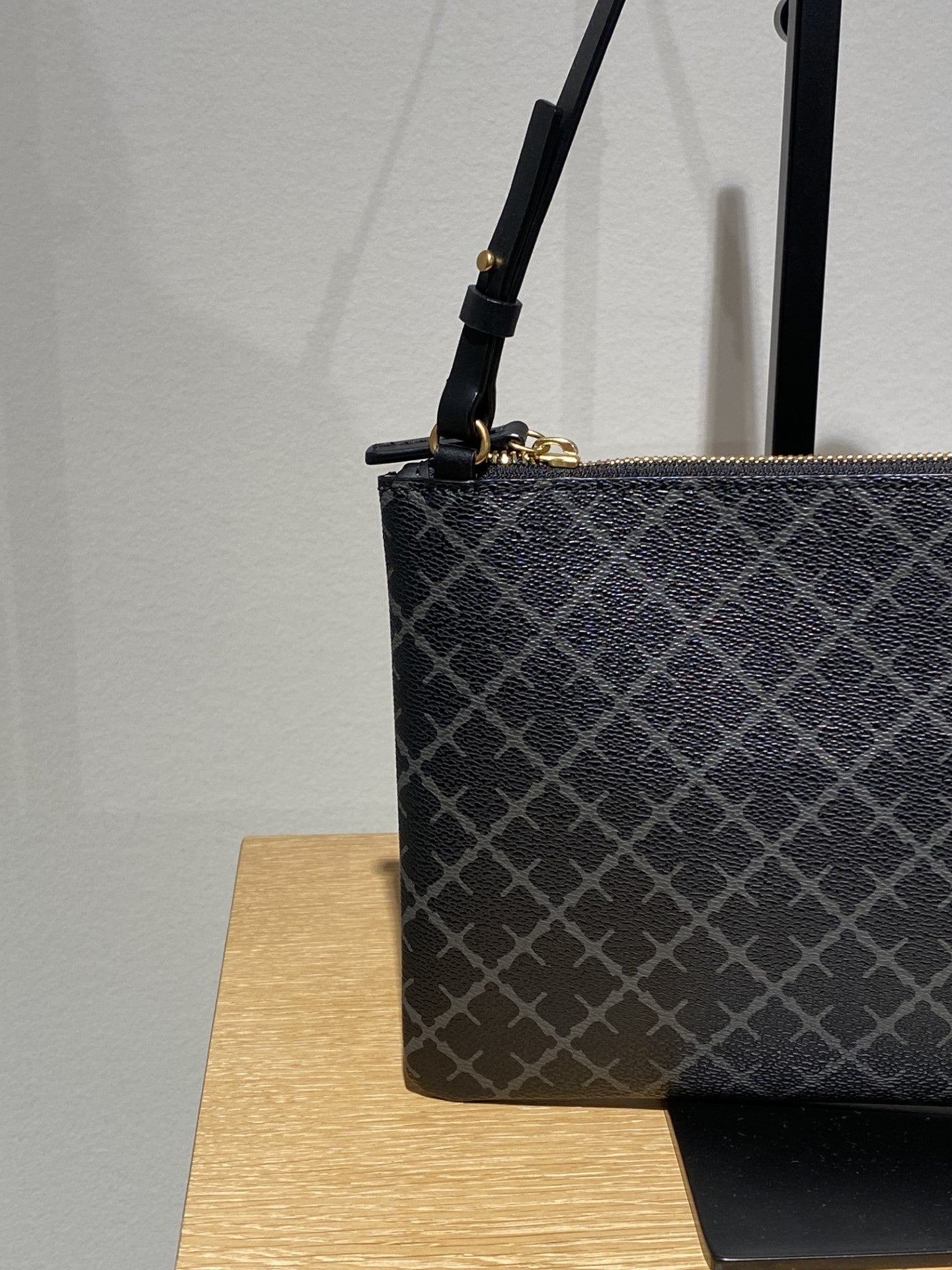 By Malene Birger Ivy veske i mørkegrå firkantet form, med Signature Flower-mønster og avtagbar stropp.