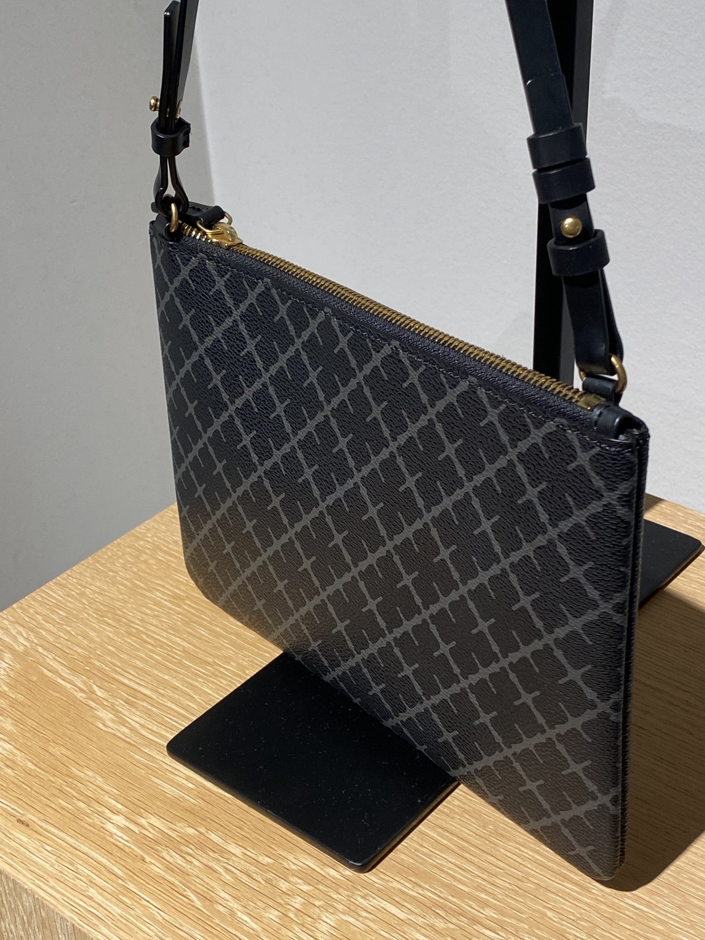 By Malene Birger Ivy veske i mørkegrå firkantet form, med Signature Flower-mønster og avtagbar stropp.