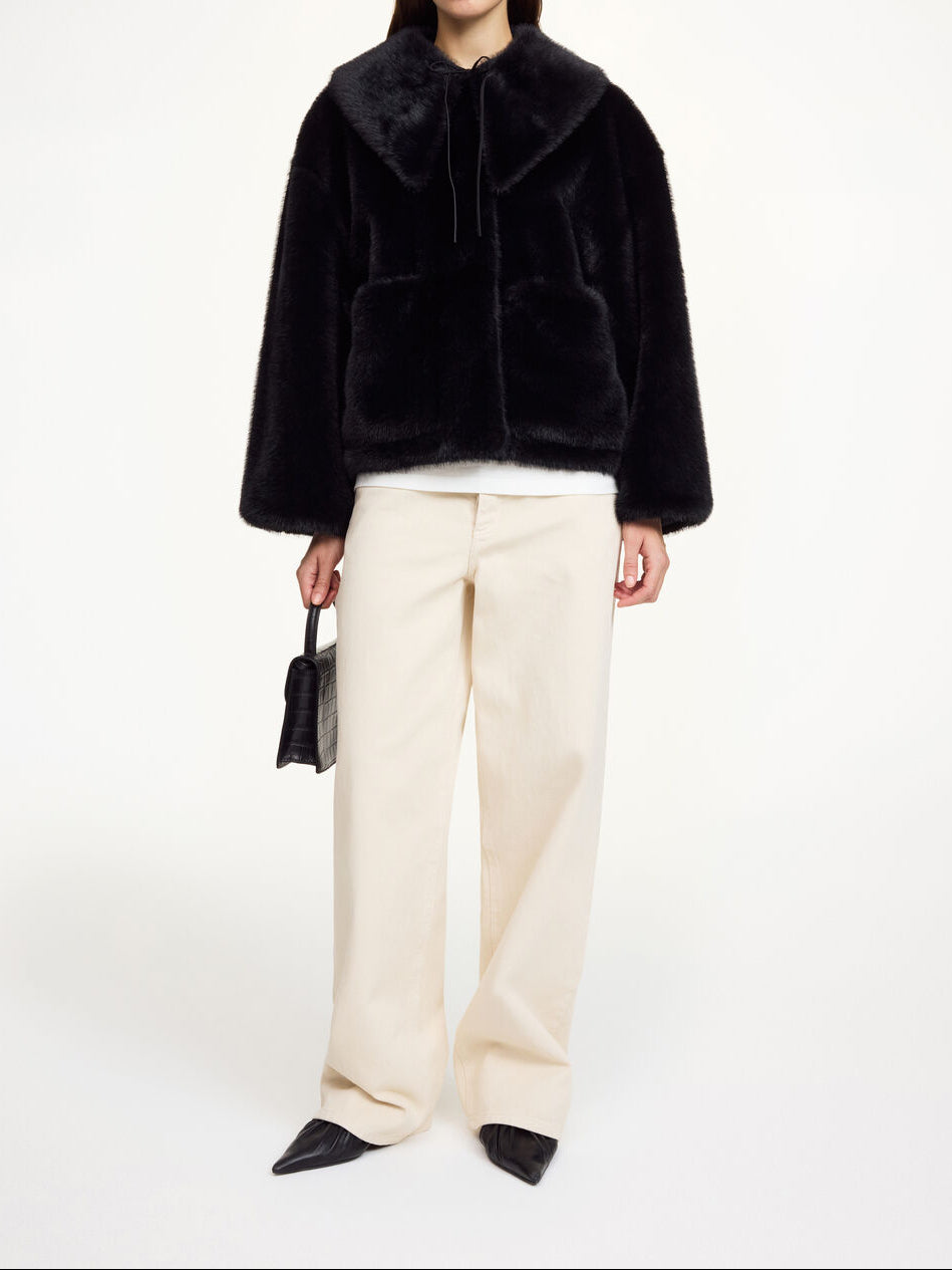 Sort fake fur-jakke i resirkulert polyester, boxy passform, avtagbar krage, store lommer