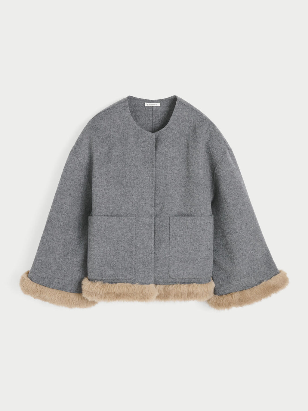 JACQUIELINE jakke fra By Malene Birger i fargen grå, laget i 100% ull med faux fur-avslutning på ermene og kroppen. U-foret med store lommer i front.