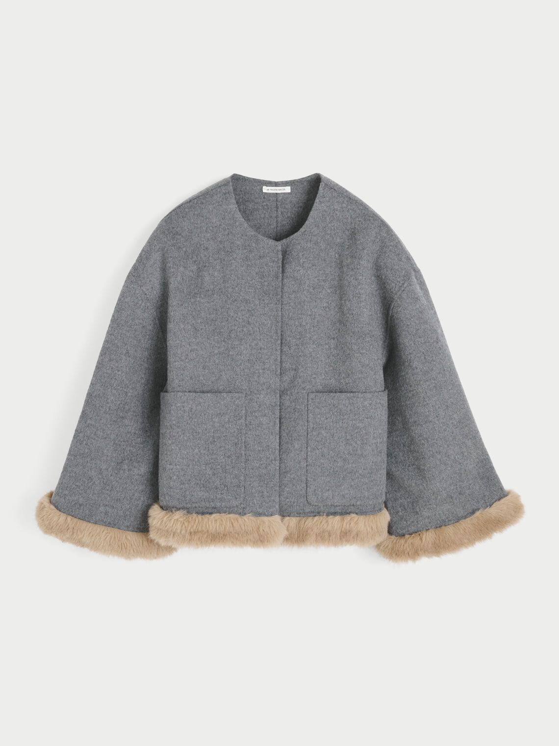 JACQUIELINE jakke fra By Malene Birger i fargen grå, laget i 100% ull med faux fur-avslutning på ermene og kroppen. U-foret med store lommer i front.