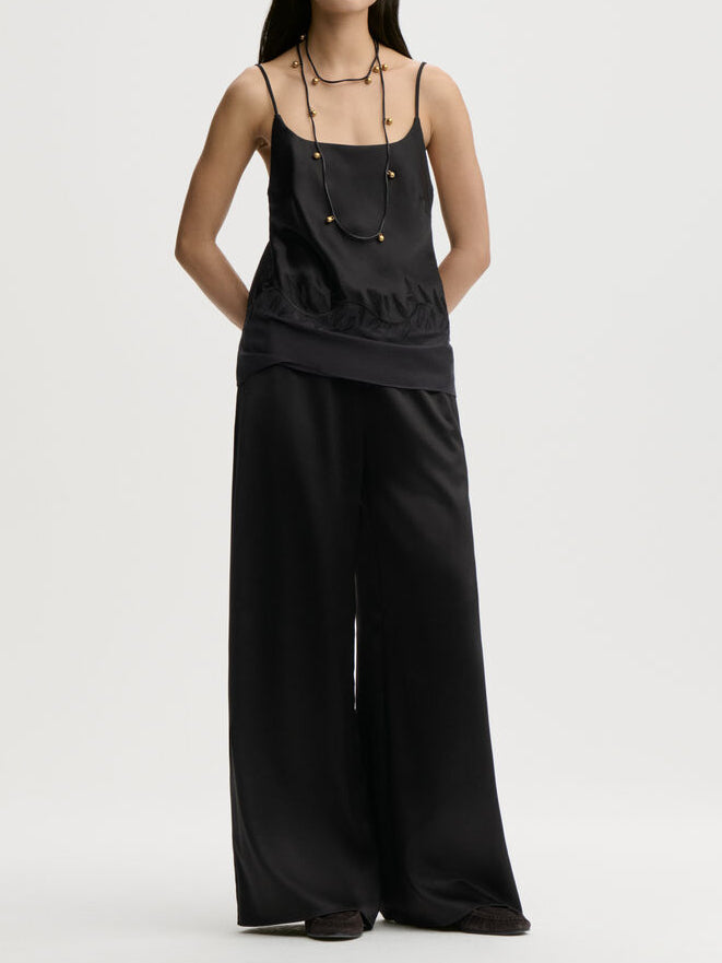JANINA singlet fra By Malene Birger i fargen sort, laget i 76% acetat og 24% polyester sateng. Rett utringning, gjennomsiktig parti nederst med brodert bord og justerbare stropper.