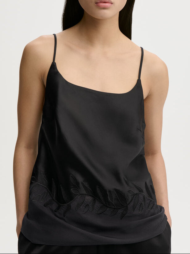 JANINA singlet fra By Malene Birger i fargen sort, laget i 76% acetat og 24% polyester sateng. Rett utringning, gjennomsiktig parti nederst med brodert bord og justerbare stropper.