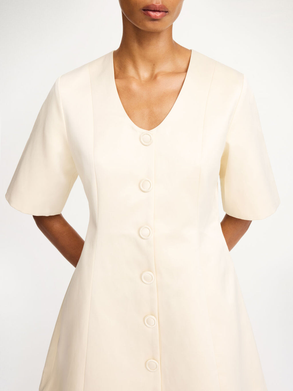 By Malene Birger Josephine kjole i hvit, med innsvinget midje, v-utringning og laget av en blanding av polyester og bomull.