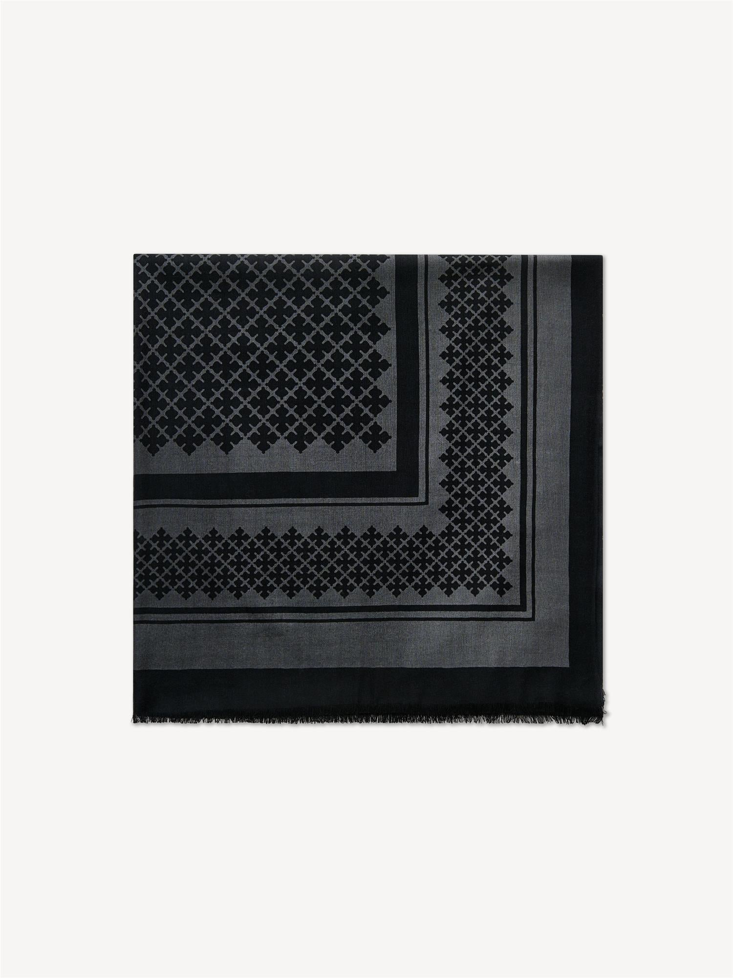 By Malene Birger Julee ullskjerf i mørk grå, med Signature Flower-print og frynser i kantene, laget av 100% ull.