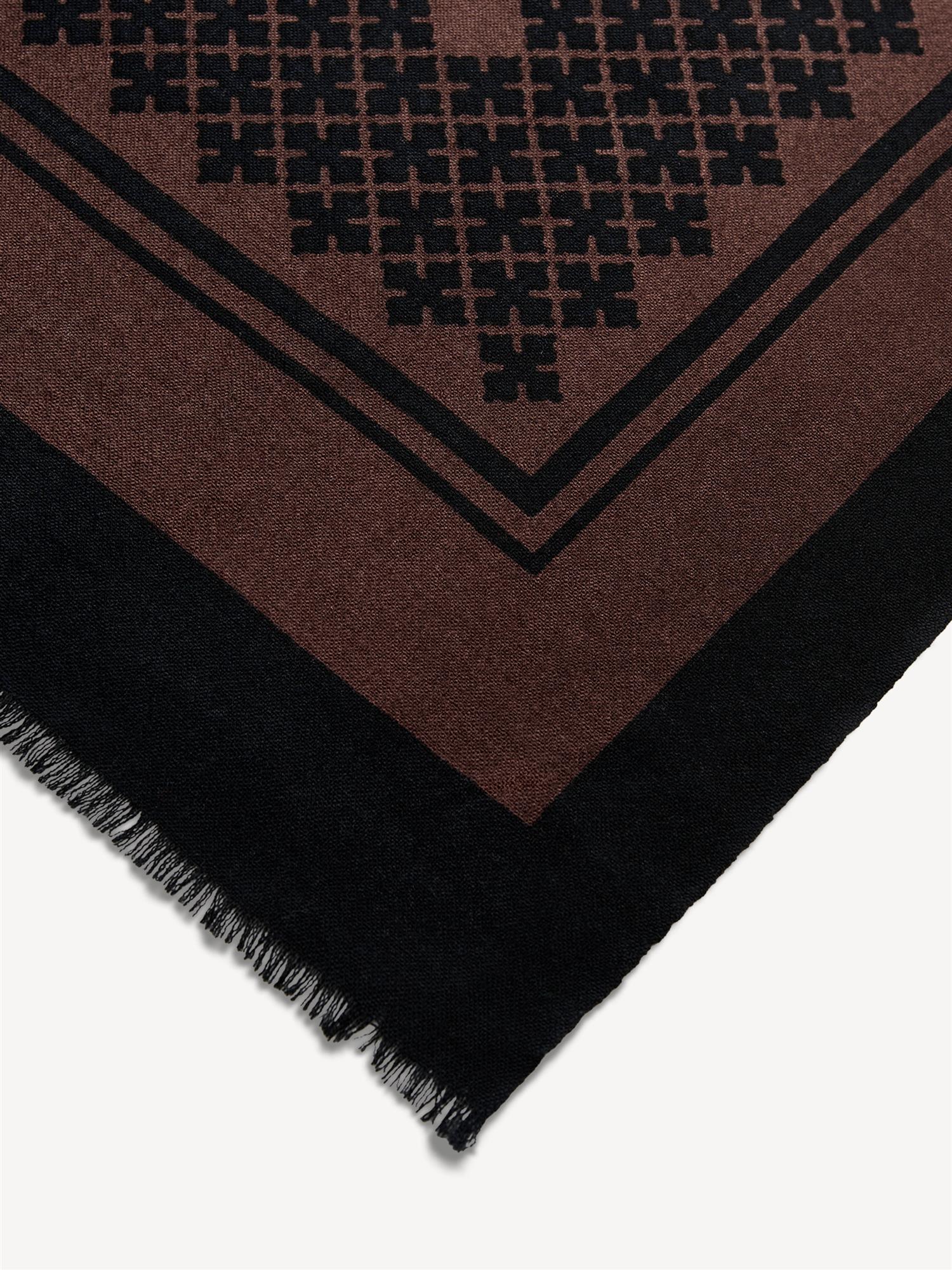 By Malene Birger Julee ullskjerf i mørkebrun, med Signature Flower-print og frynser i kantene, laget av 100% ull.