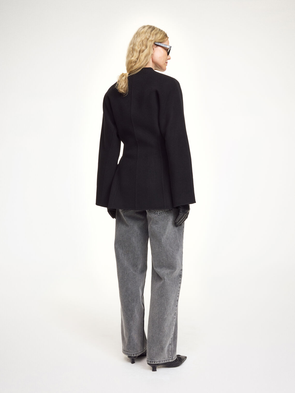 Lalou ulljakke i fargen sort fra By Malene Birger laget i hundre prosent RWS-sertifisert ull. Jakken er en feminin variant av den klassiske blazeren med et elegant omslag som kan knytes på flere måter. Den har splitter på ermene, praktiske lommer i front og en justerbar lukking som gir et tidløst og moderne uttrykk.
