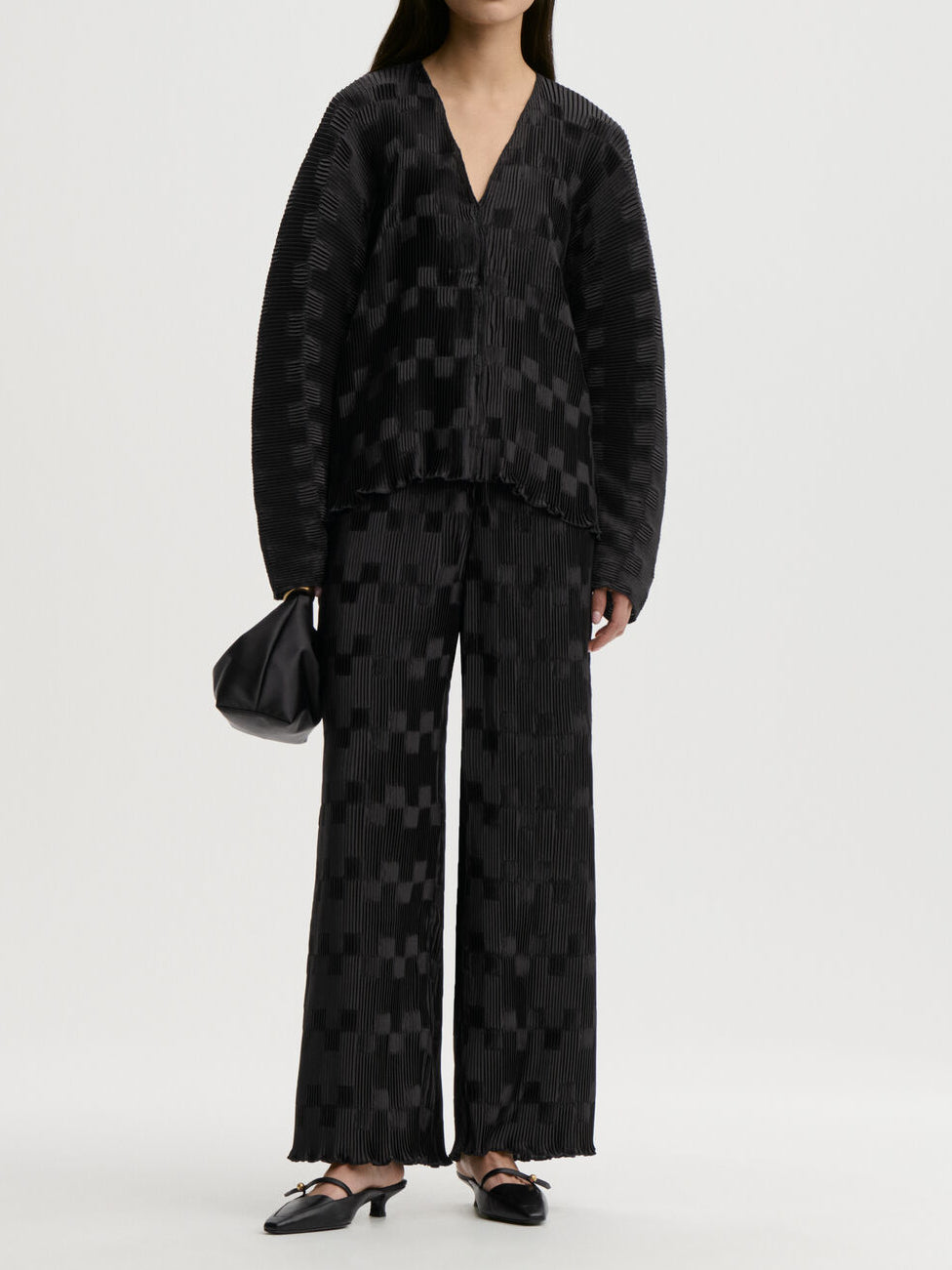 LETITA plissebukse fra By Malene Birger i fargen sort, laget i 100% resirkulert polyester. Rette ben og strikk i livet.