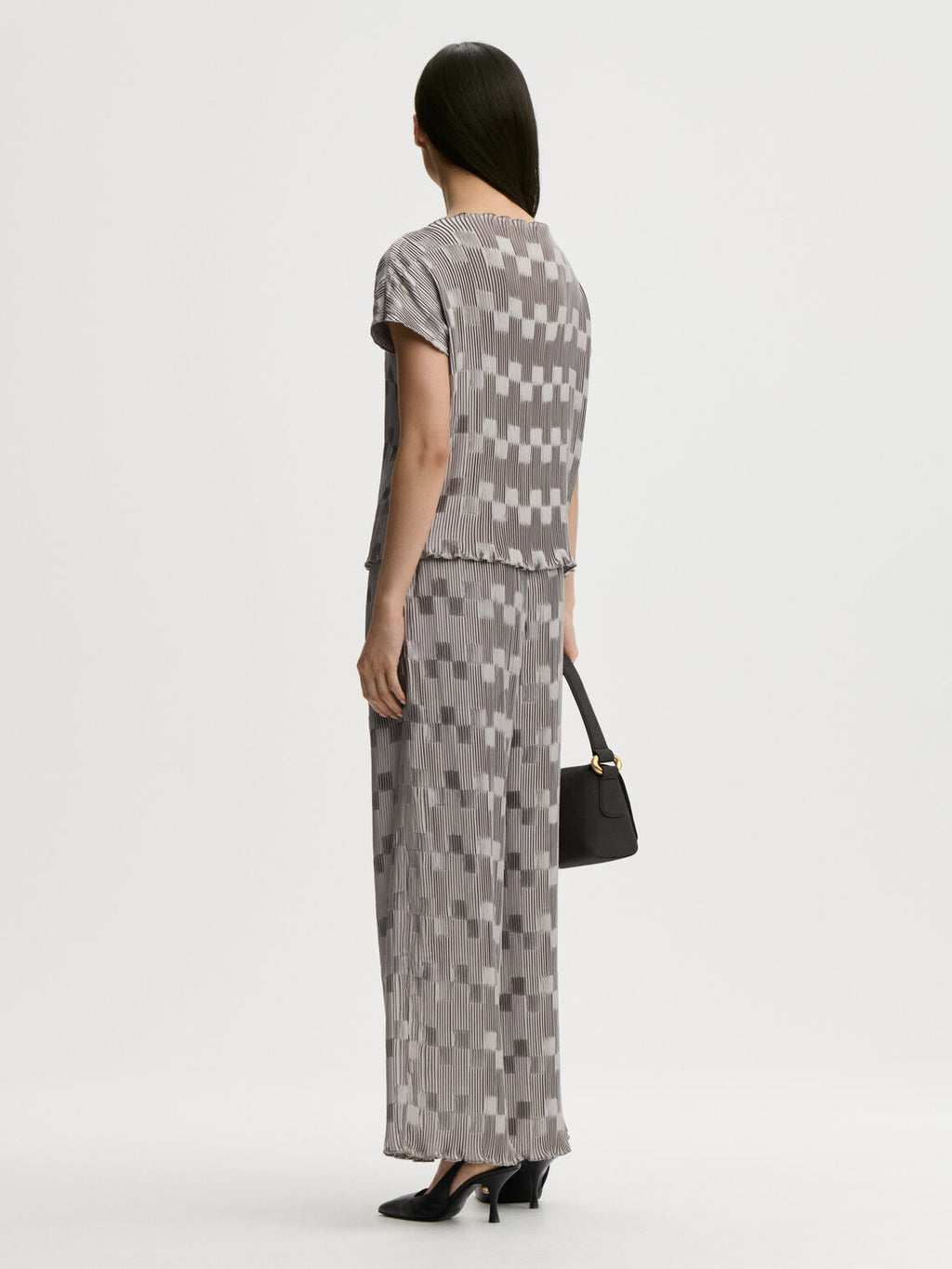 LIANNA plissebluse fra By Malene Birger i fargen sølv, laget i 100% resirkulert polyester. Båthals, dropped skuldre og en avslappet, flatterende passform.