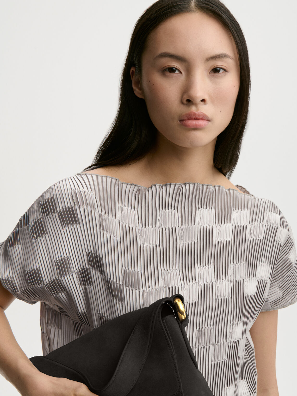 LIANNA plissebluse fra By Malene Birger i fargen sølv, laget i 100% resirkulert polyester. Båthals, dropped skuldre og en avslappet, flatterende passform.