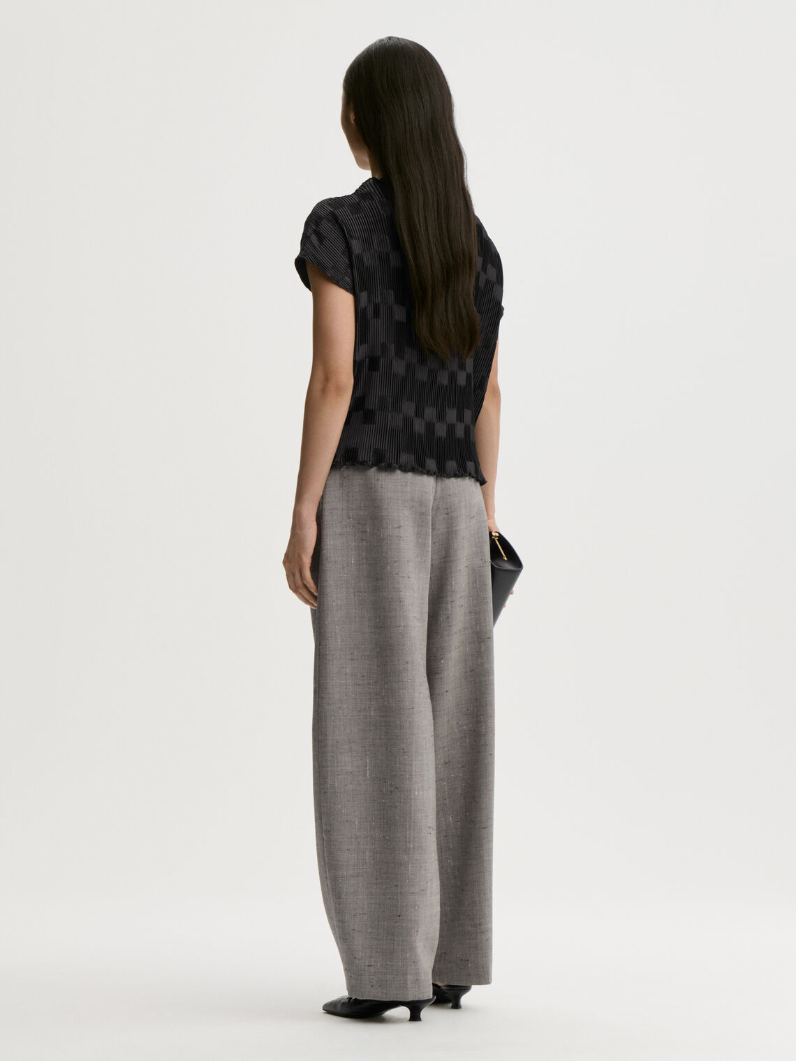 LIANNA plissebluse fra By Malene Birger i fargen sort, laget i 100% resirkulert polyester. Båthals, dropped skuldre og en avslappet, flatterende passform.