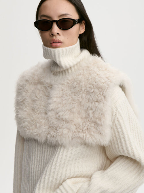 LILA pelskrage fra By Malene Birger i fargen kremfarget, laget i 100% ekte naturlig kalvehår og skinn. Langhåret og lukkes med en hempe.