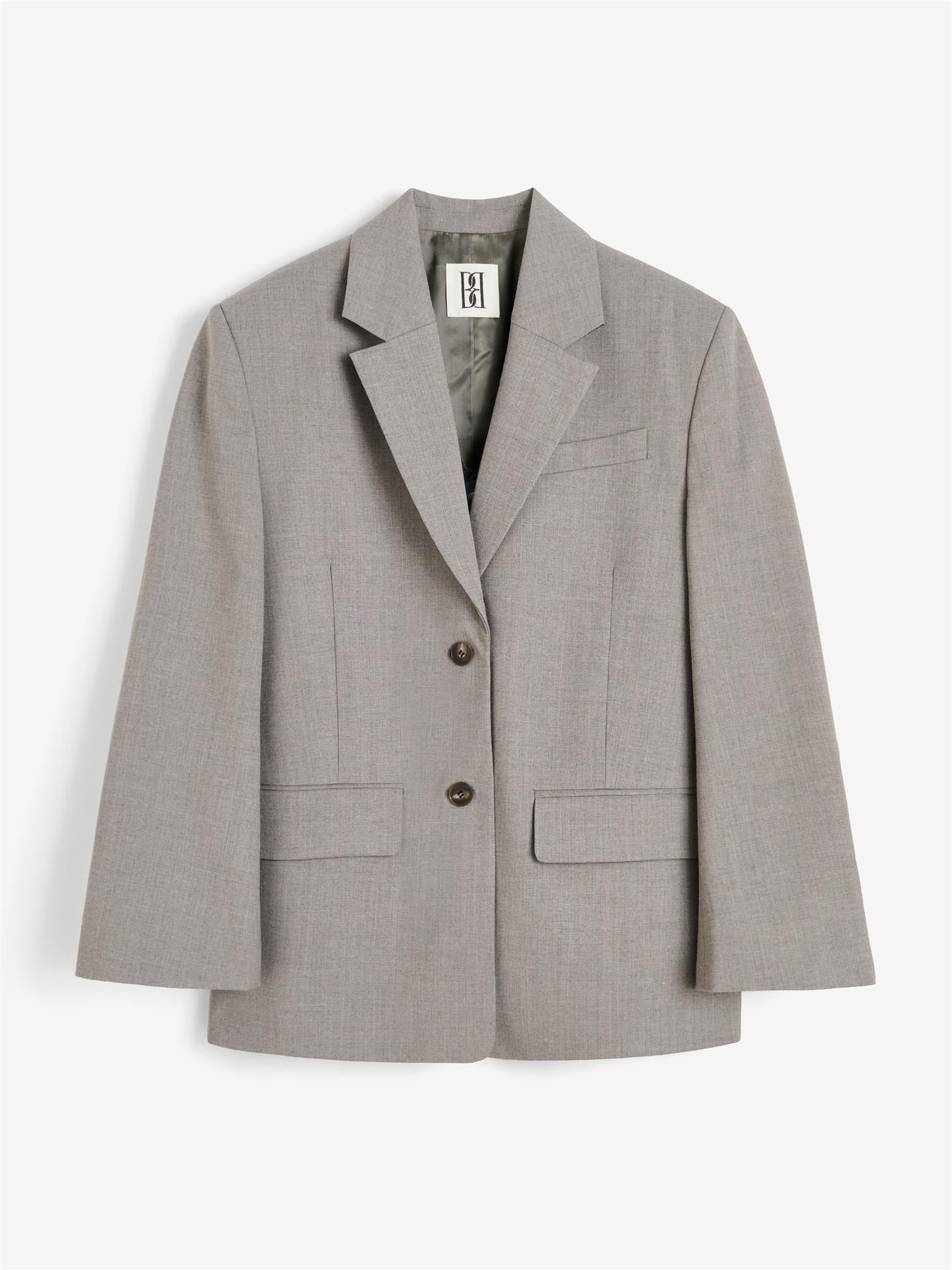 LIVA blazer fra By Malene Birger i grå med brun melering. Laget i ull, polyester og viskose med enkeltspent lukking, lommer i front, innvendig lomme og foret konstruksjon. Noe lang og løs passform.