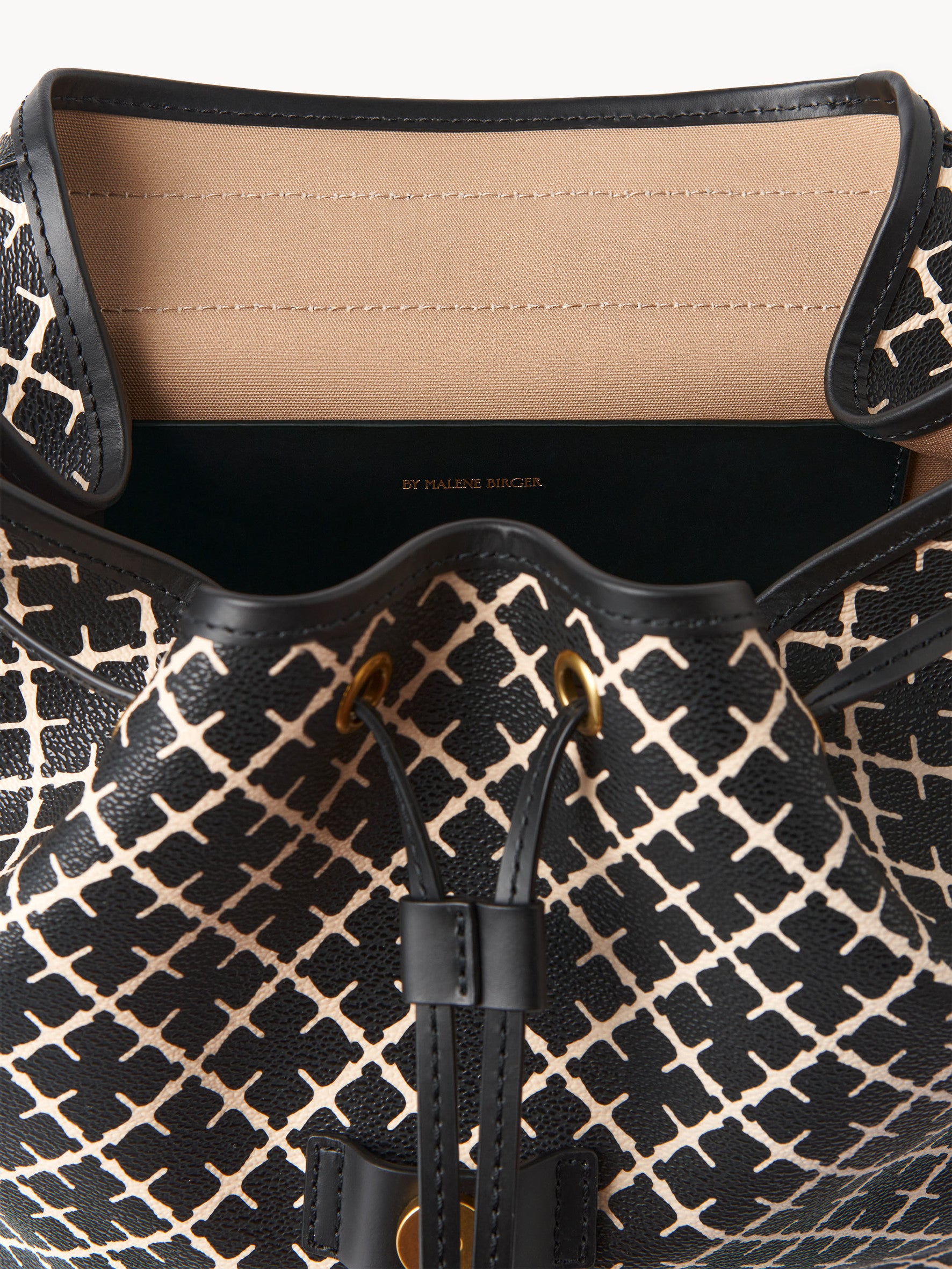 By Malene Birger Loenlo ryggsekk i sort, med Signature Flower-mønster, brede stropper og klafflukking.

