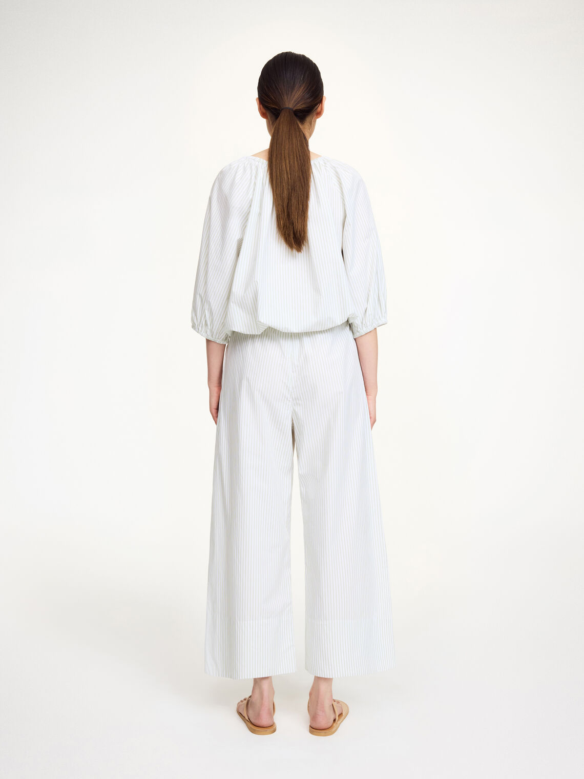 By Malene Birger Luisa bukse i hvit med grønne, tynne striper, laget av 100% organisk bomull med en cropped lengde og vide ben.