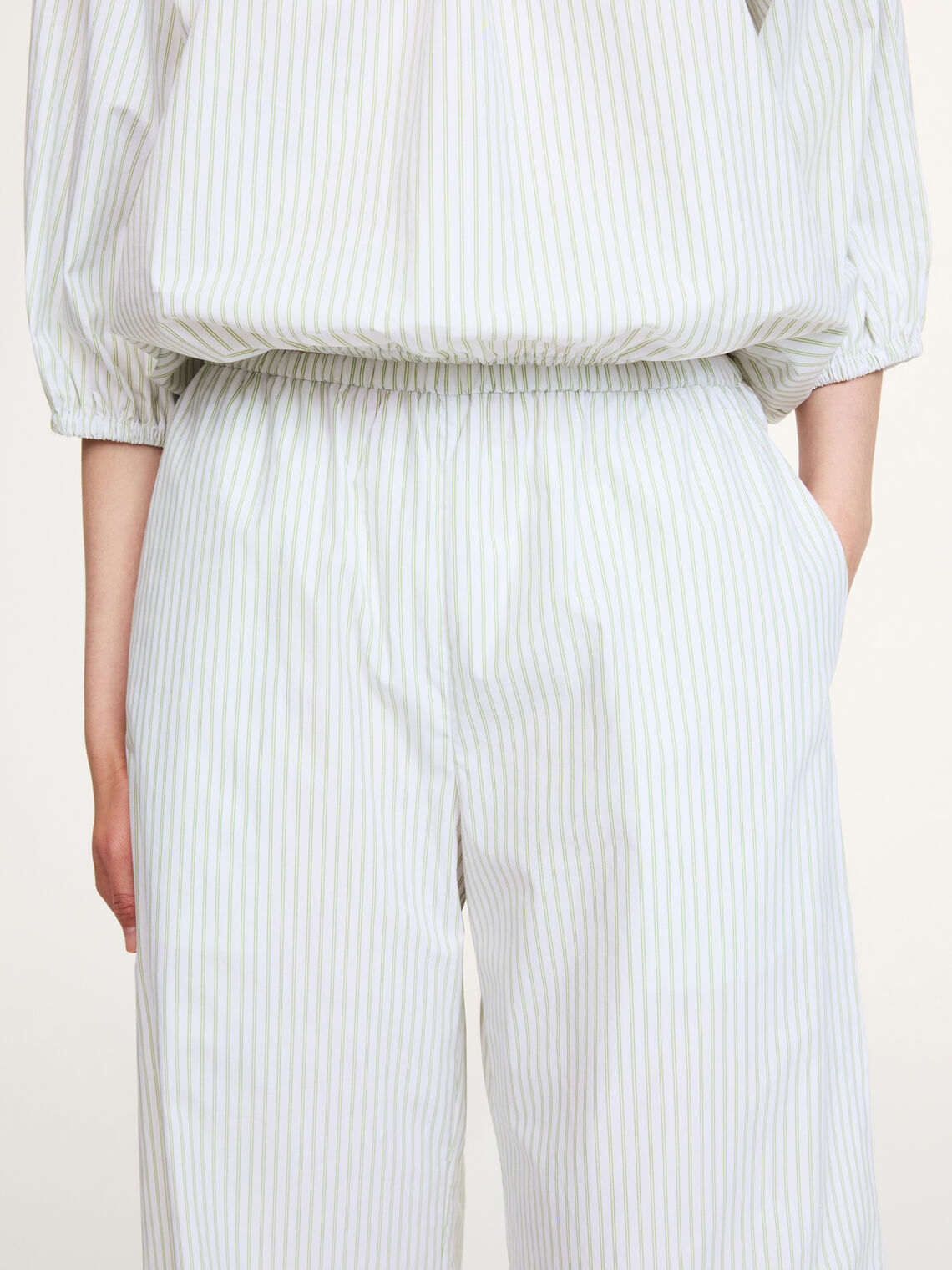 By Malene Birger Luisa bukse i hvit med grønne, tynne striper, laget av 100% organisk bomull med en cropped lengde og vide ben.