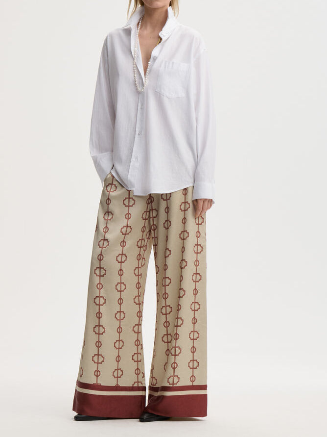 LUNIA bukse fra By Malene Birger med egenutviklet print, laget i 85% acetat og 15% polyester. Høyt liv, strikk i livet, vide ben og lommer i siden.