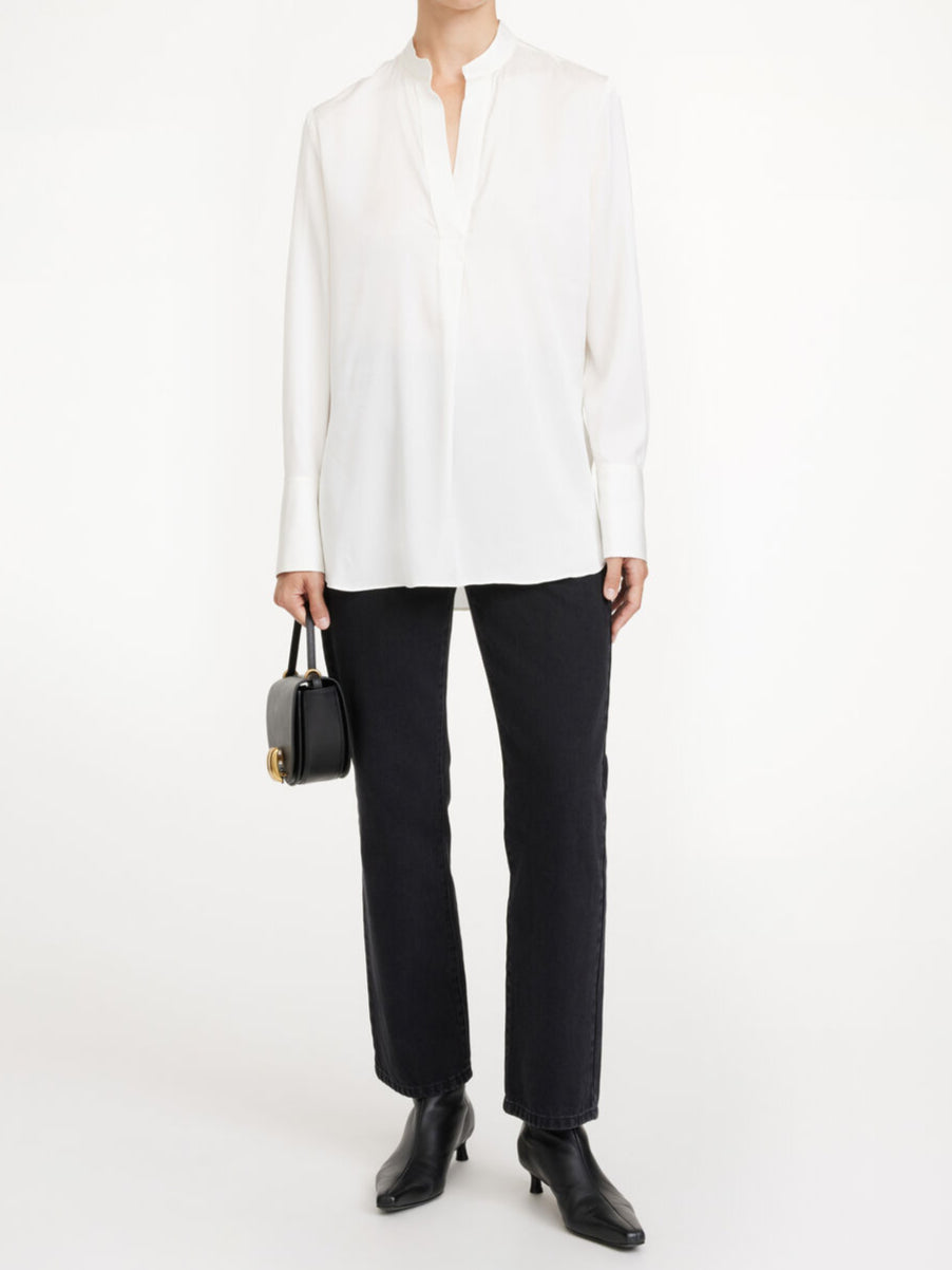 By Malene Birger Mabillon bluse i hvit, laget av en blanding av silke og elastan, med en v-utringning og knapper på mansjettene.