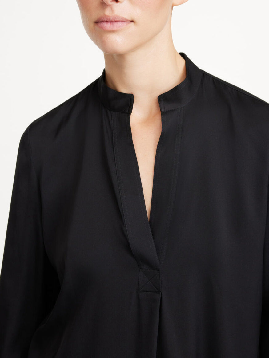 By Malene Birger Mabillon bluse i sort, laget av en blanding av silke og elastan, med en v-utringning og knapper på mansjettene.