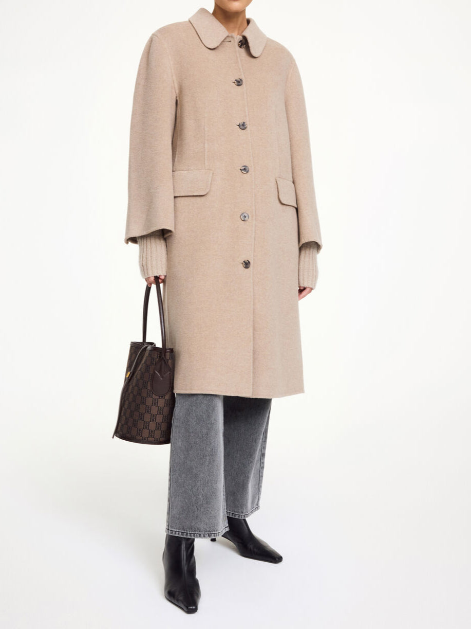 By Malene Birger Maelle kåpe i beige, med en rett passform, buet krage og laget av 100% ull.