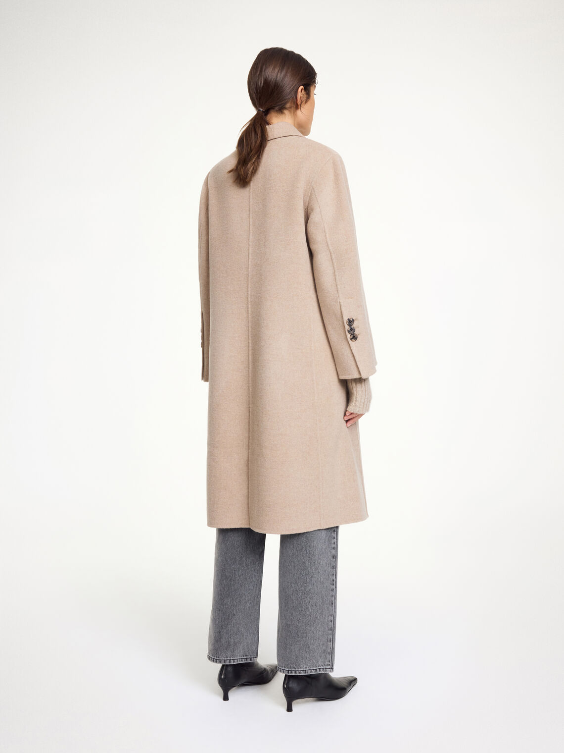 By Malene Birger Maelle kåpe i beige, med en rett passform, buet krage og laget av 100% ull.
