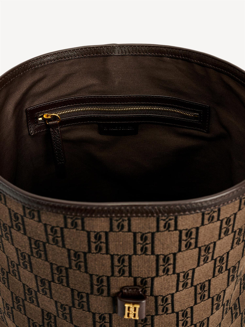 By Malene Birger Maryllon veske i brun, med bøtteform, laget av resirkulert bomull og polyester, og et gullfarget monogram-emblem i front.