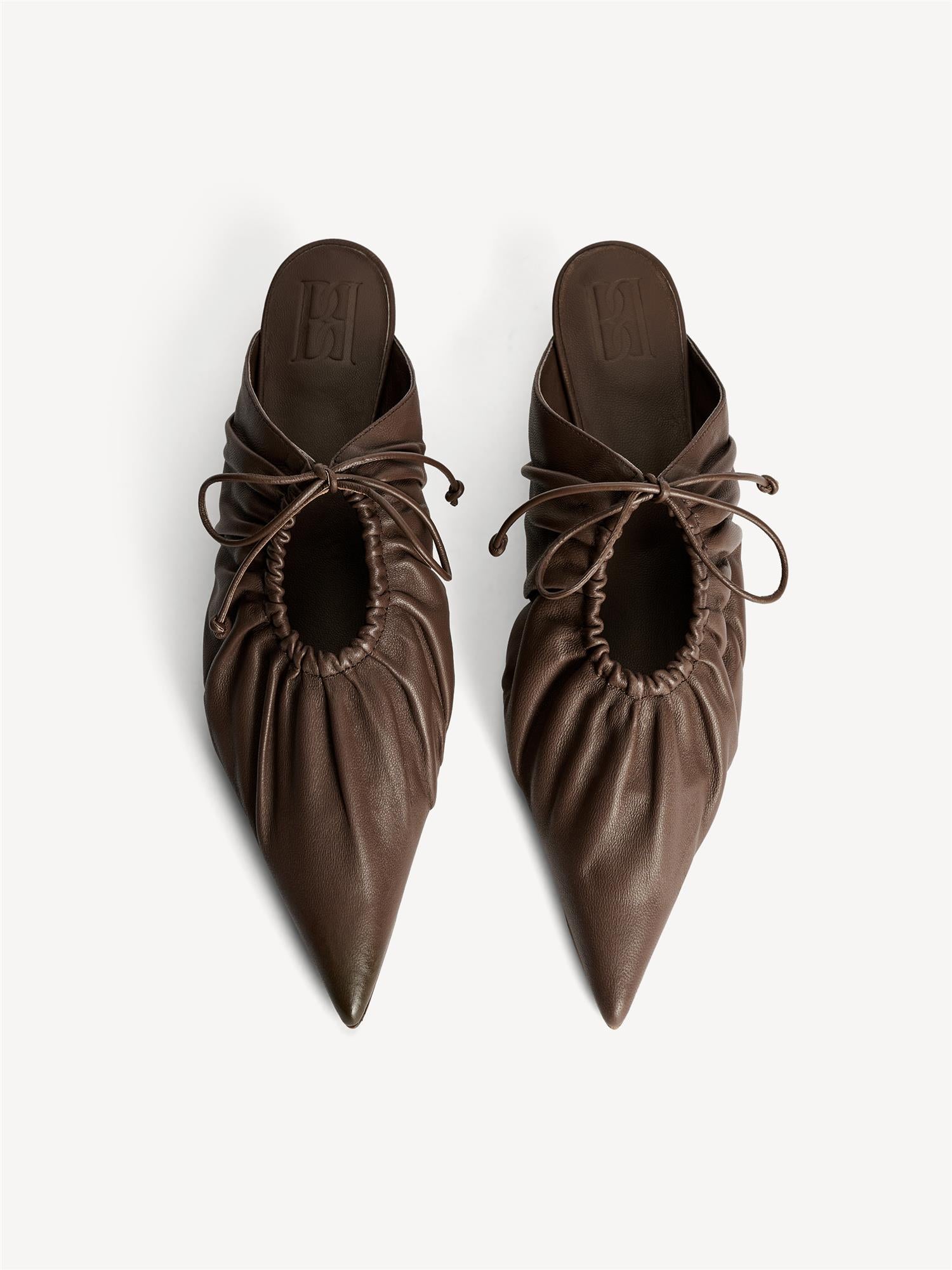 By Malene Birger Masey skinnmules i fargen carafe brun, laget av geiteskinn, med kitten-heels og en spiss silhuett.