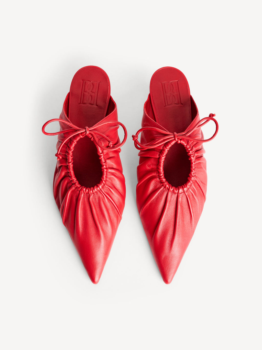 By Malene Birger Masey skinnmules i rød, laget av geiteskinn, med kitten-heels og en spiss silhuett.